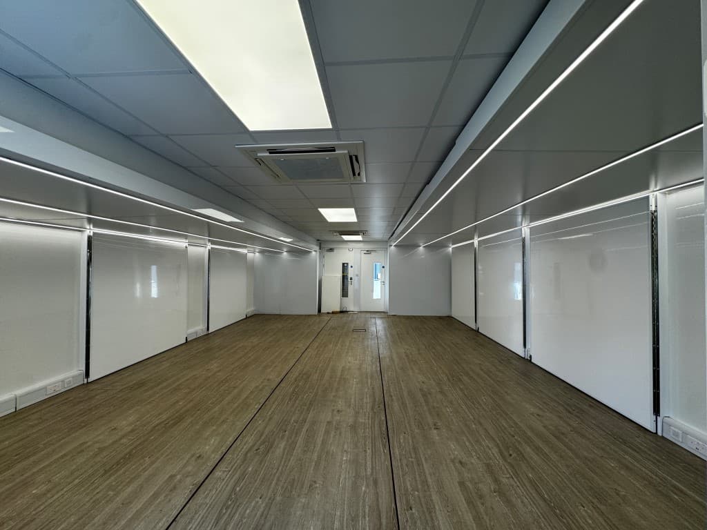 Open interior of an expandable trailer with fitted lighting and wood-effect flooring