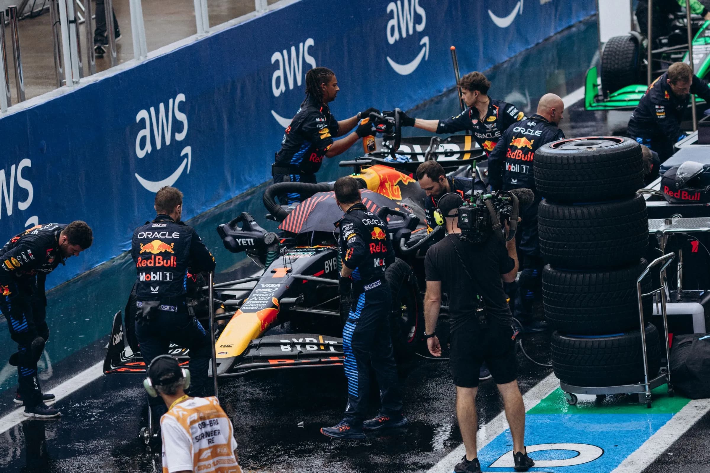 Formula One pit crew working beside a car in the rain