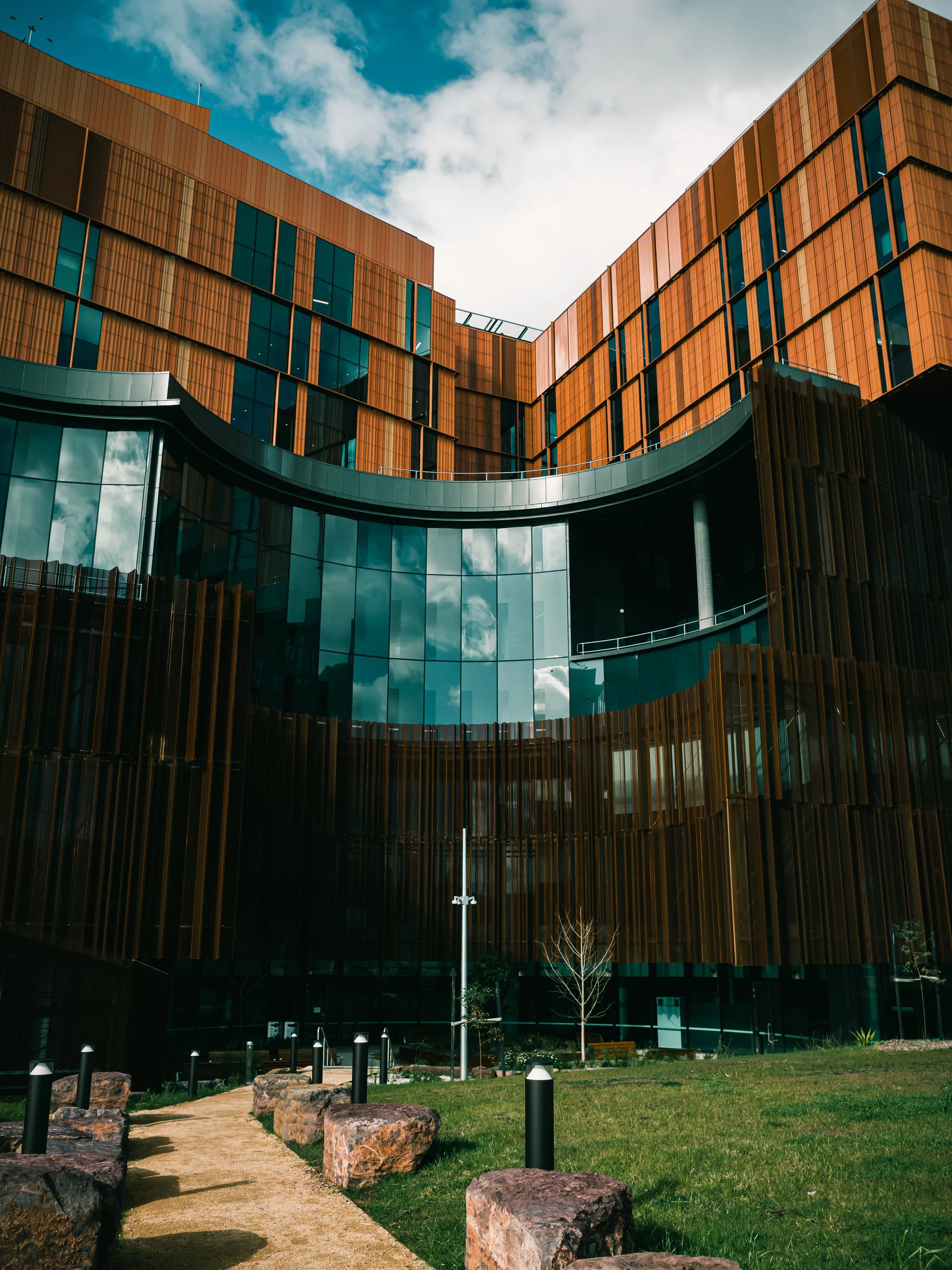 Contemporary hospital architecture with copper-toned facades and curved glass walls
