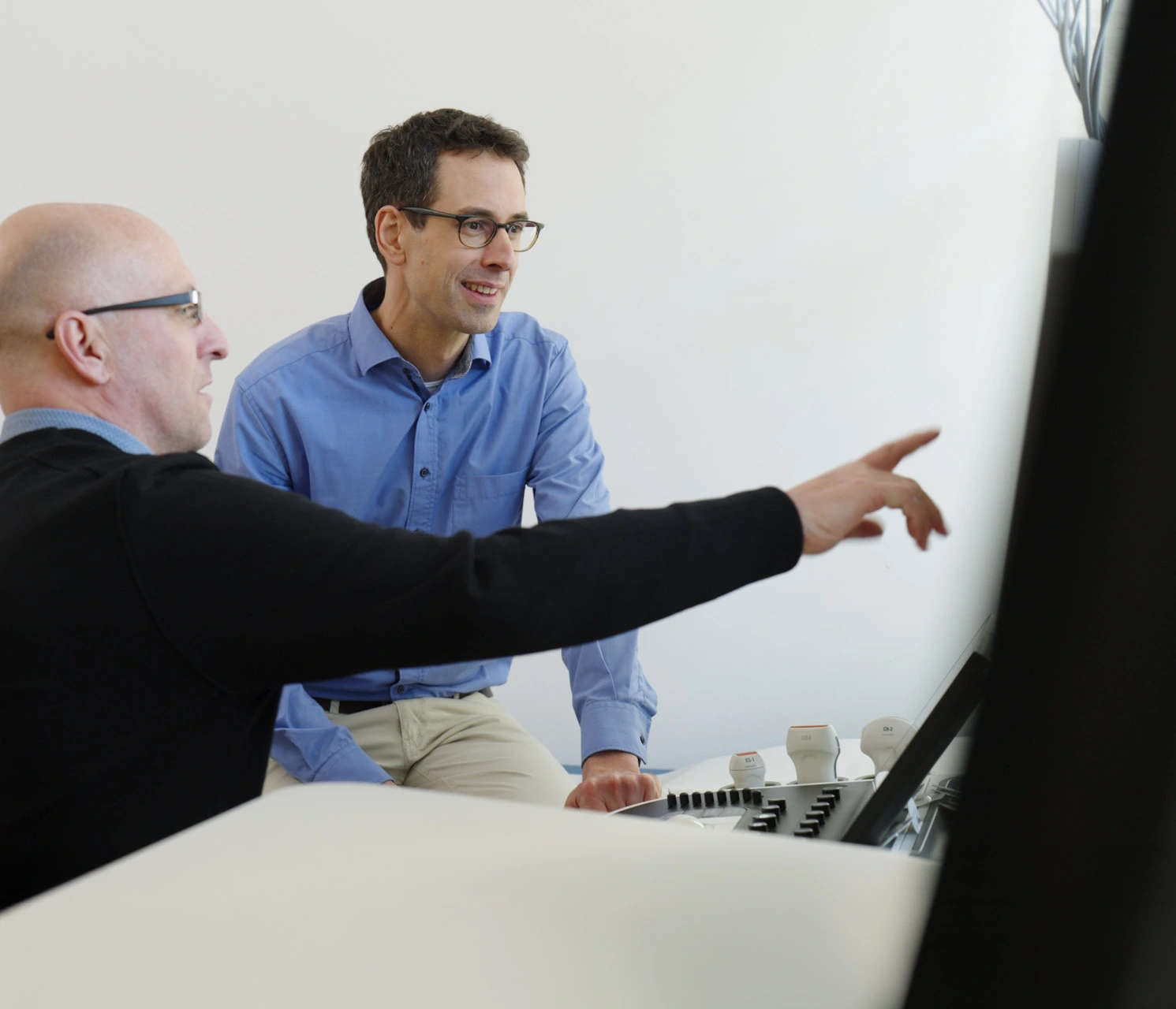A clinician and a service specialist review images on a Philips EPIQ system.