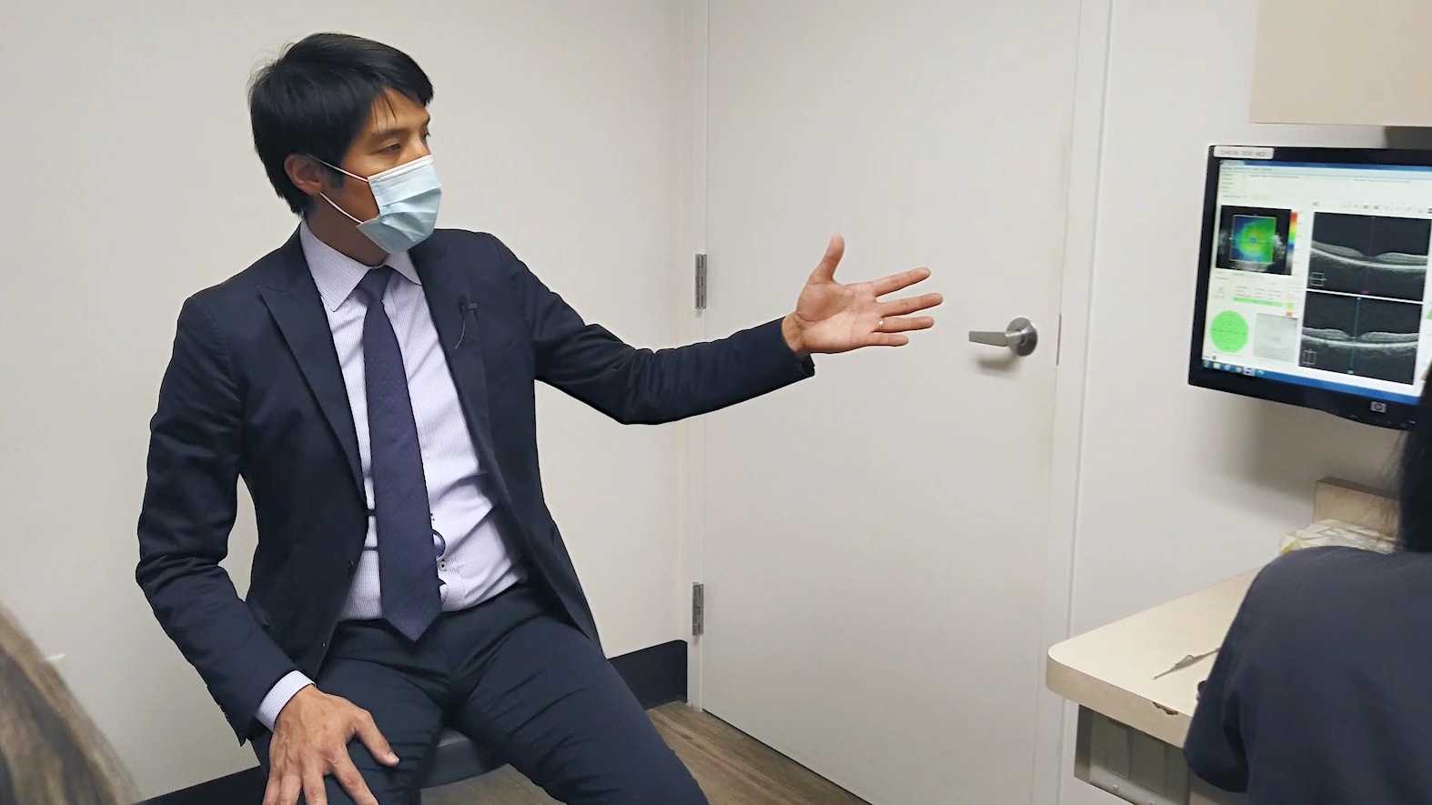 An ophthalmologist reviews findings during a patient consultation.