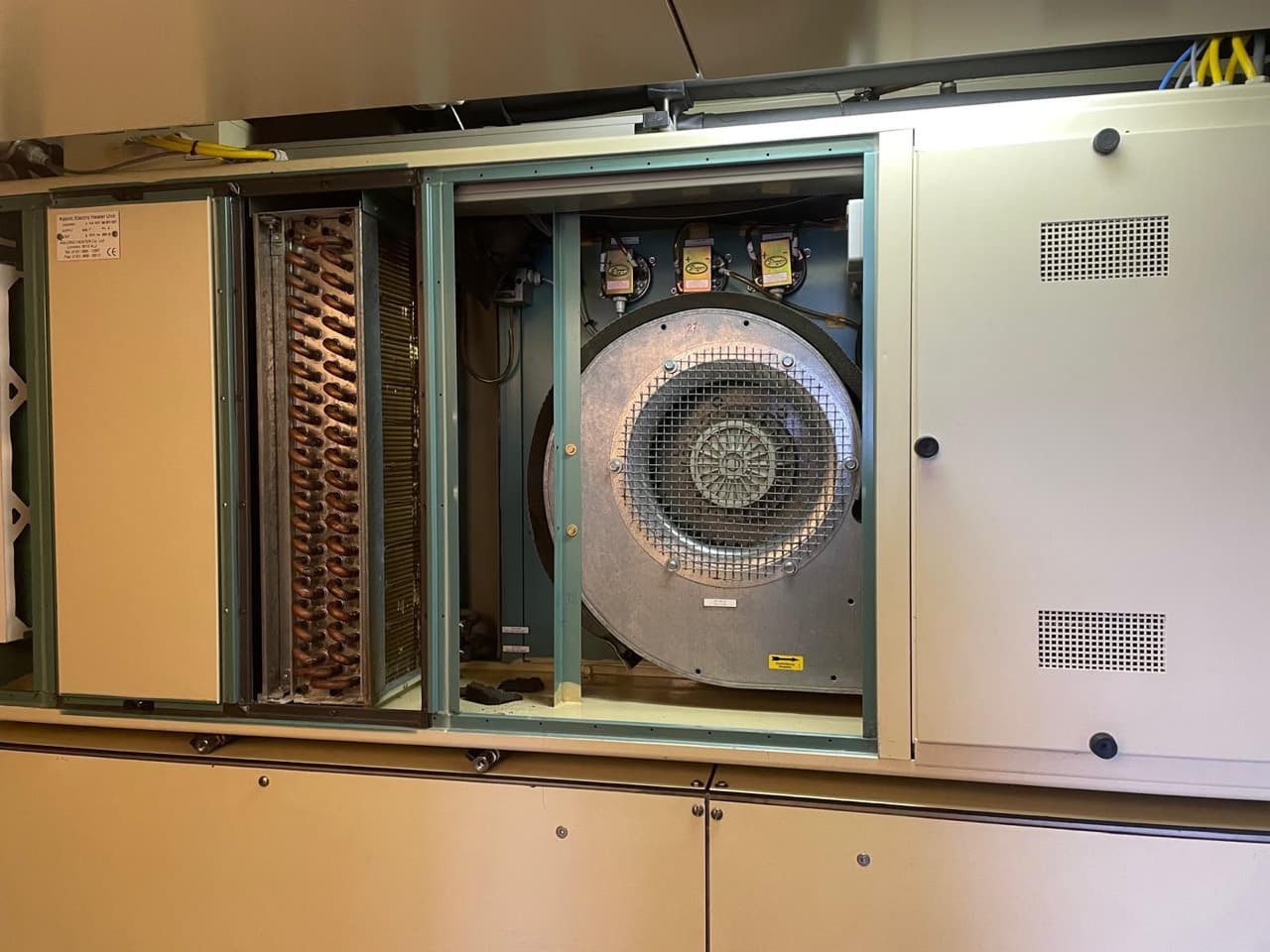 Open air-handling cabinet showing the fan assembly and adjacent coil