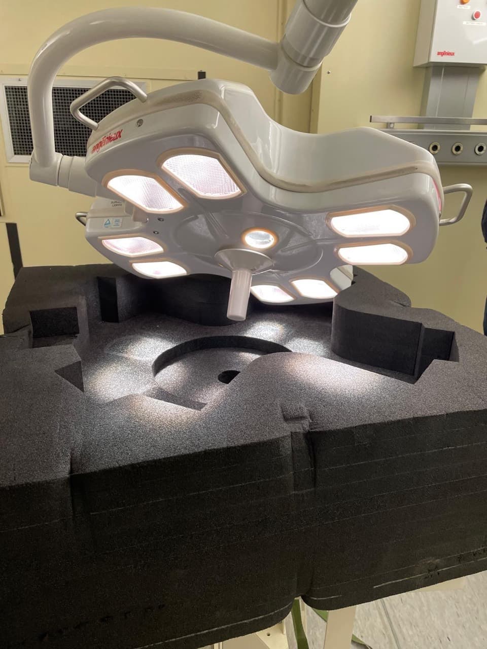 Illuminated surgical light head resting in protective transport foam