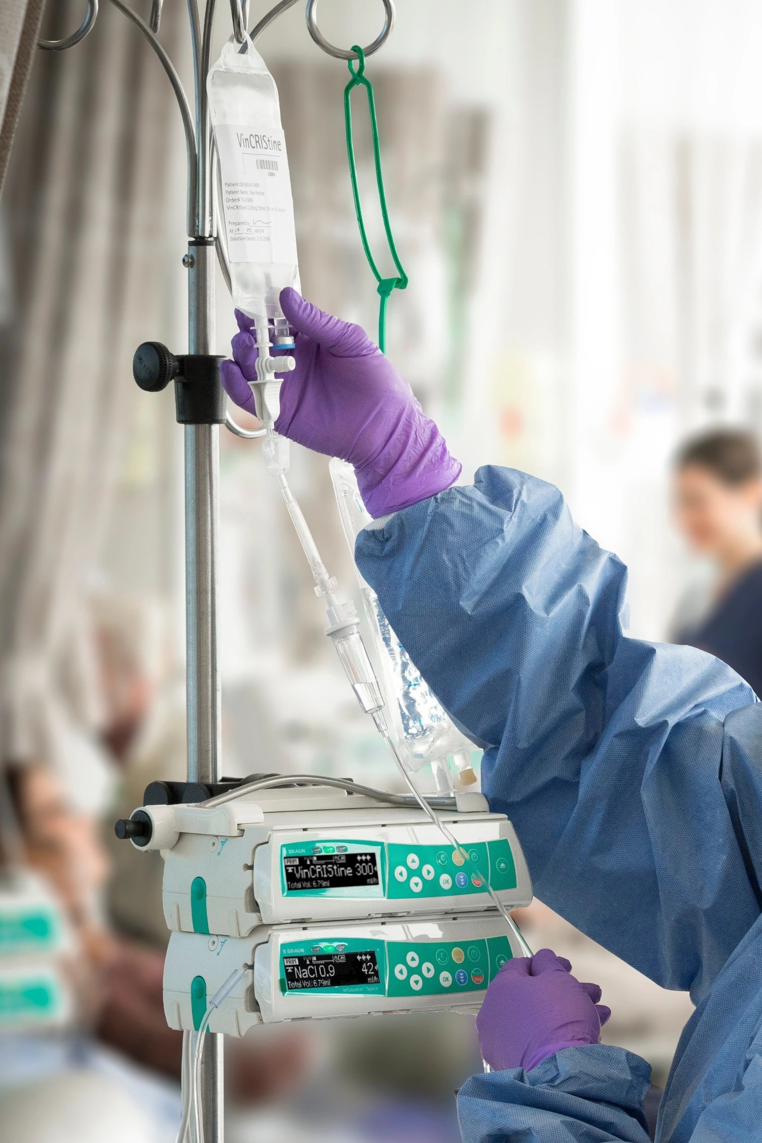 Gloved hands beside an infusion bag and two stacked B. Braun Infusomat Space pumps.