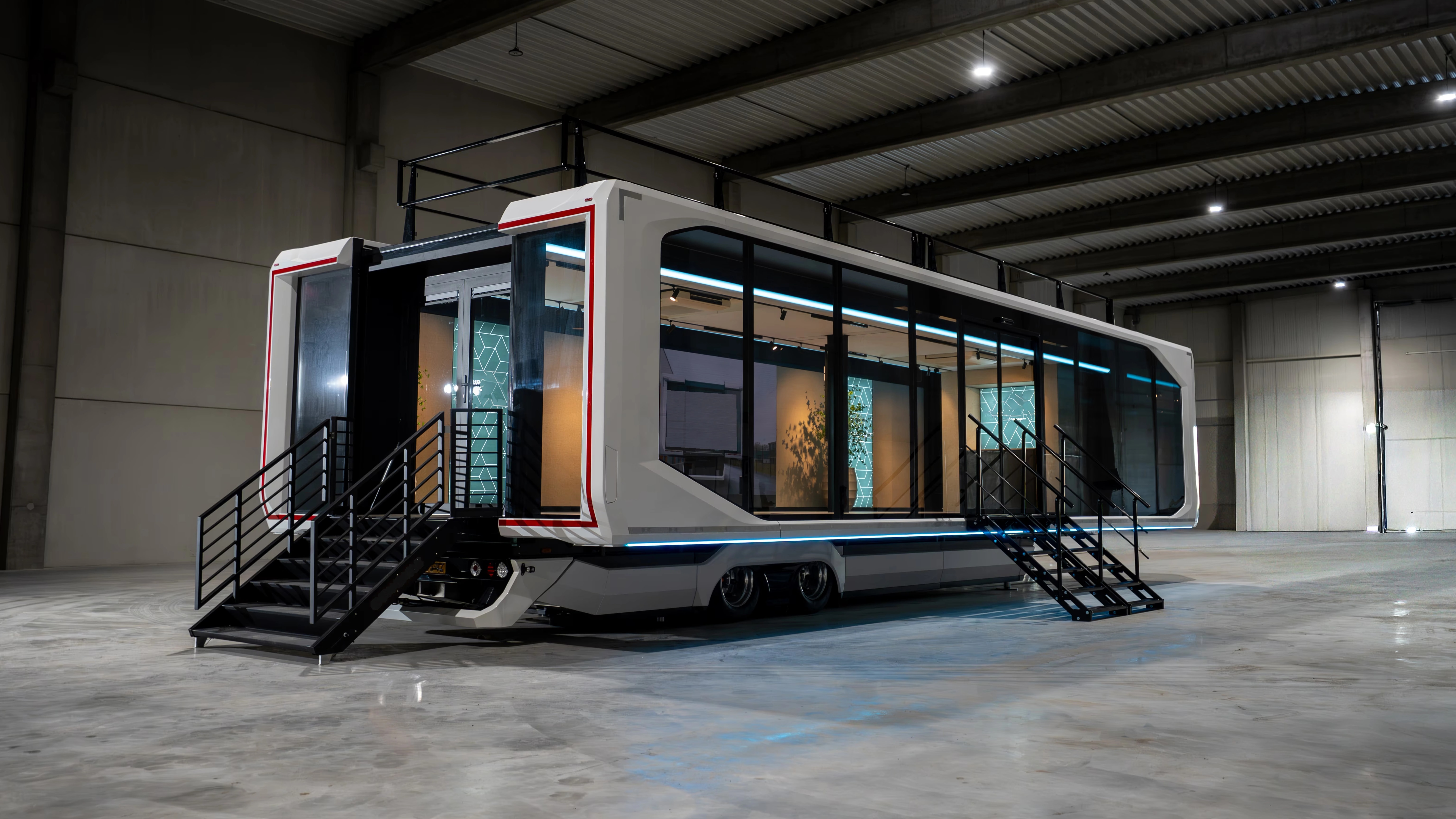 An expanded long semi-trailer with its side sections and access stairs deployed in a warehouse.