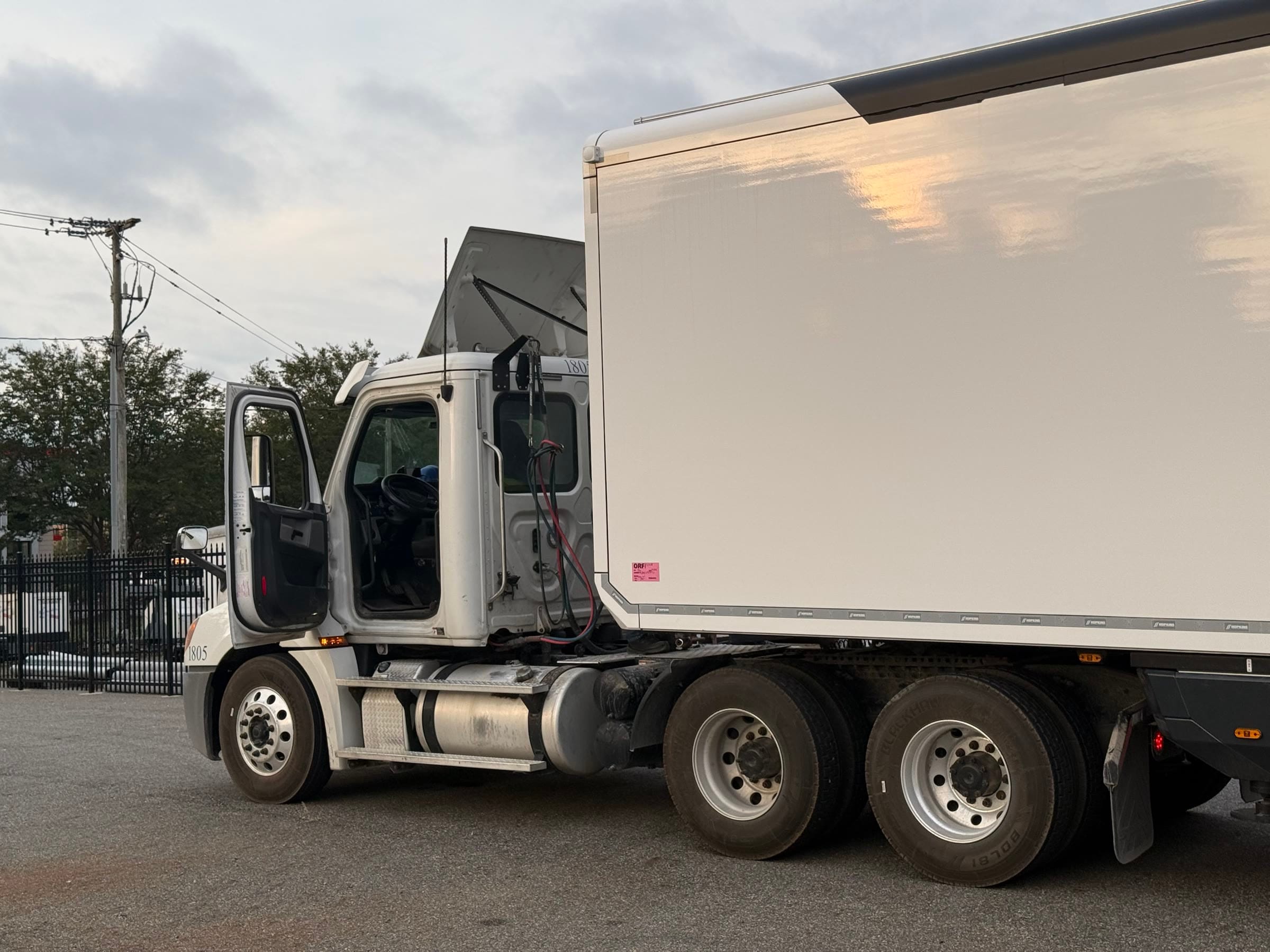 Tractor unit with its door open beside the closed expandable unit