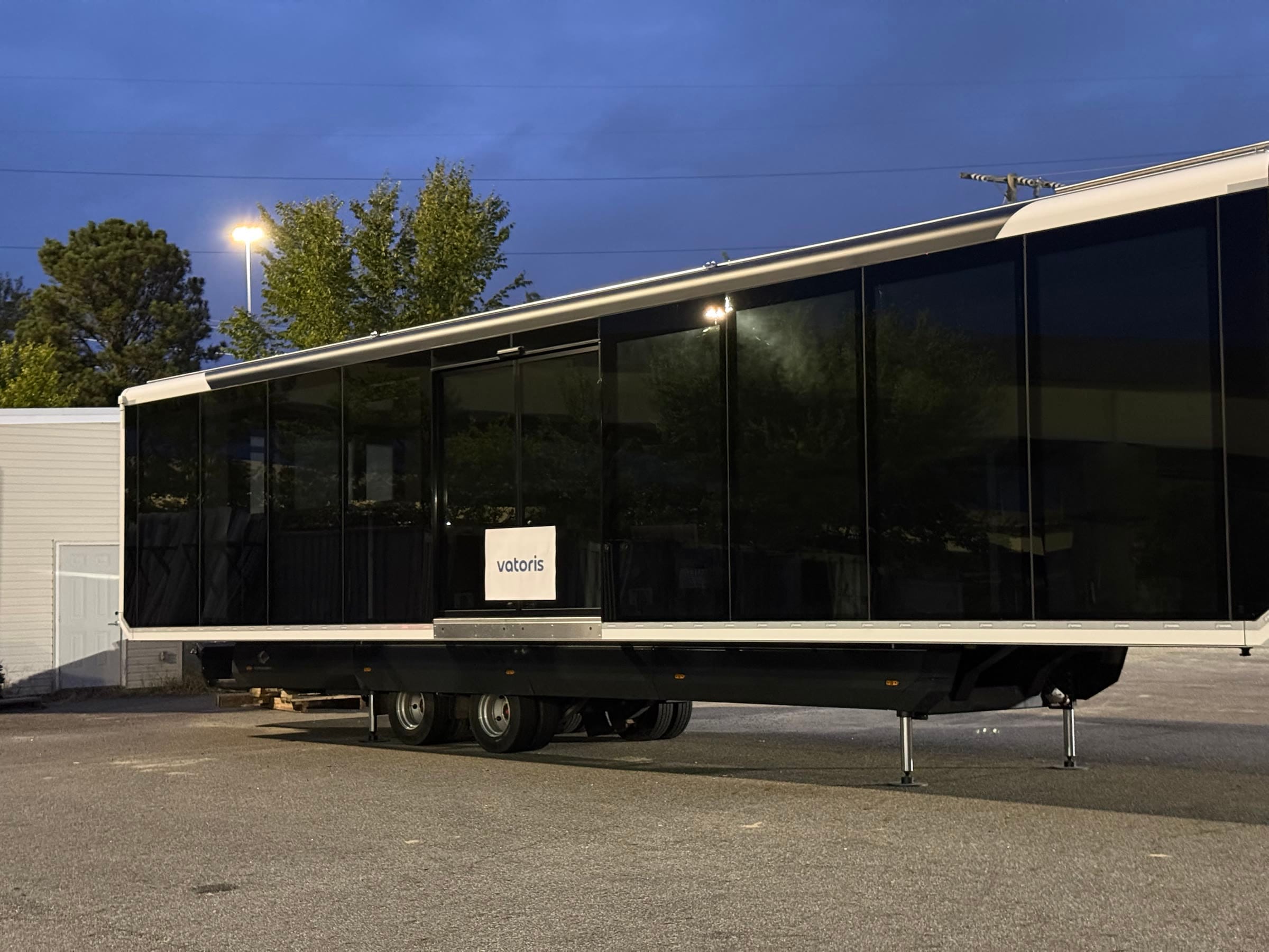 The glass side and double doors of the expandable unit at dusk
