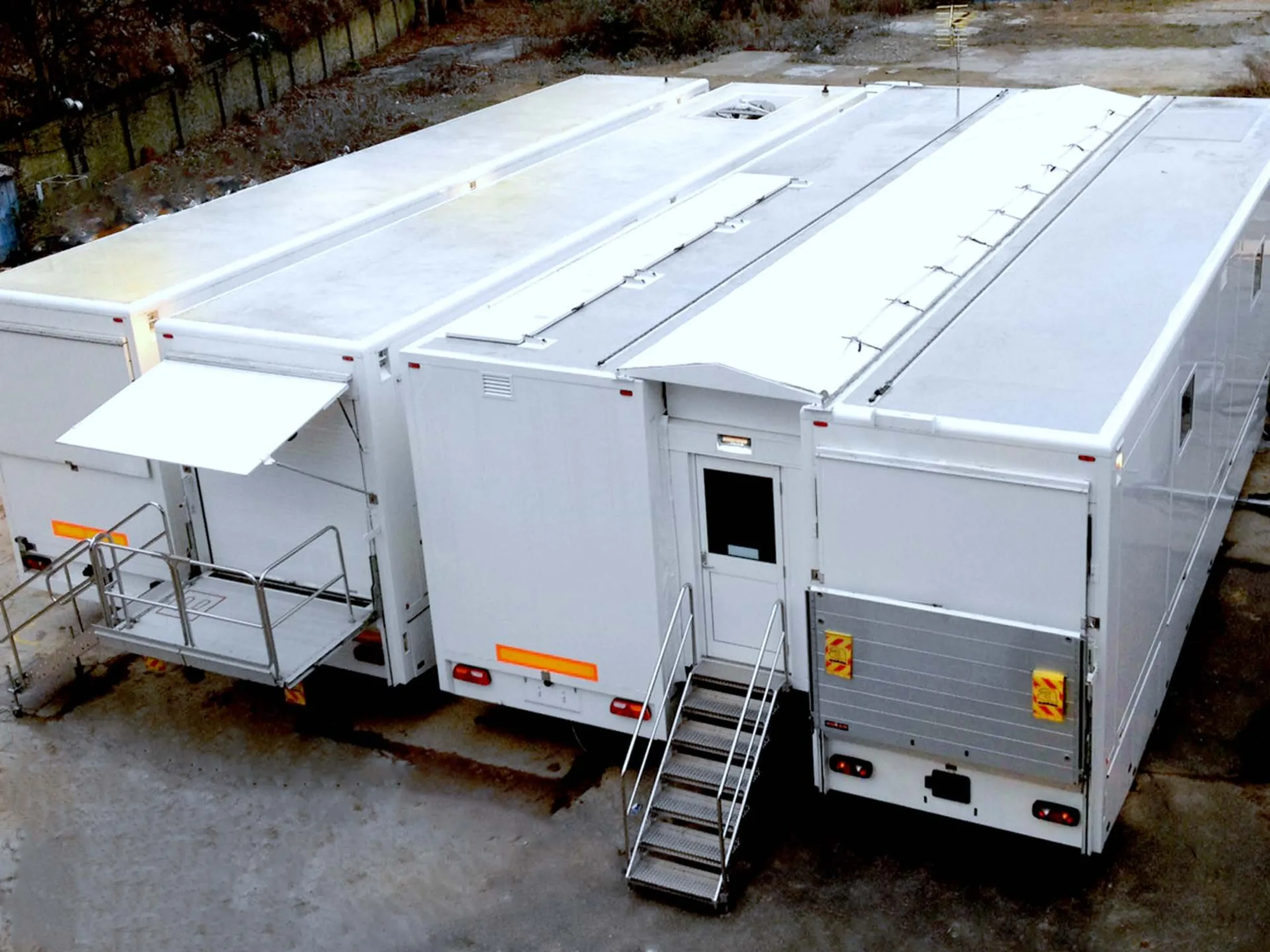 Four connected trailers with awnings and access steps