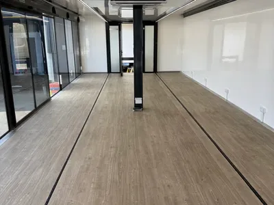 Expandable trailer interior with glazed doors and wood-vinyl flooring