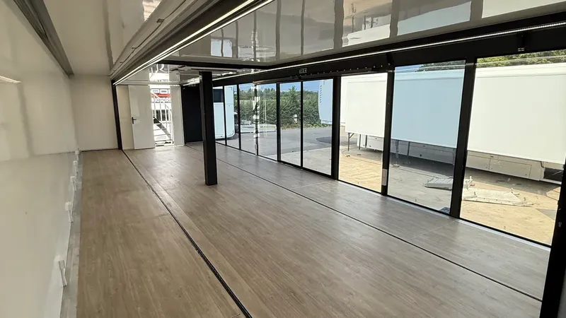 Expandable trailer interior with glazed doors and wood-vinyl flooring